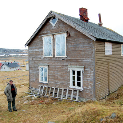 Svein Harald Holmen (t.h.) sammen med Magnus Borgos, tidligere saksbehandler i Kulturminnefondet, ved siden av Holmenhuset. Holmen er så engasjert i bevaring av flere kulturminner i Vardø, at hans eget hus i Hamningberg havner litt i andre rekke. (Foto: Einar Engen/Kulturminnefondet)