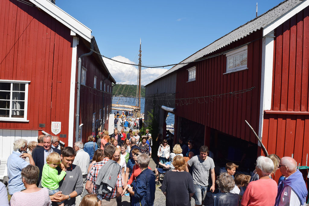 Under trebåtfestivalen i Risør bugner det med folk på Moen. Her mellom buene hos Gregersen. (Foto: Einar Engen/Kulturminnefondet)