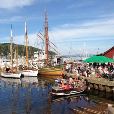 SJ Skreien har fått utført nødvendige arbeider ved Promhavn slipp på Nærsnes i Buskerud. Her ligger hun til kai (båten med høyest mast) ved et arrangement for lokalbefolkningen og tilreisende. (Foto: Norsk Forening for Fartøyvern)