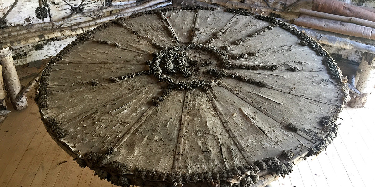 Midt i rommet står et rundt bord dekket av never og dekorert med kongler. Detaljene er unike, og svært godt bevart tross sin høye alder. (Foto Ellen Jacobsen)