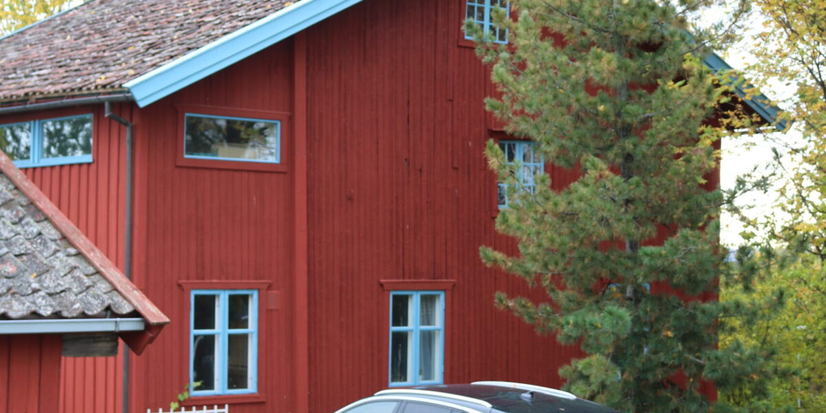 Bildet viser rødt hus og en gul bil.