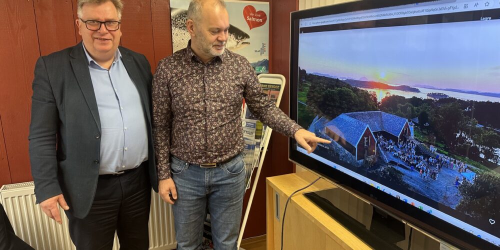 Atle Hamar og styreleder i Stiftelsen Svanøy Hus, Ola Teigen, peker på låven der vinduene skal restaureres.